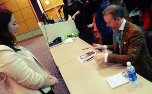 David Zyla signing a student's program. 