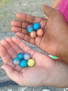 The hands of my friend and I holding paintballs. 